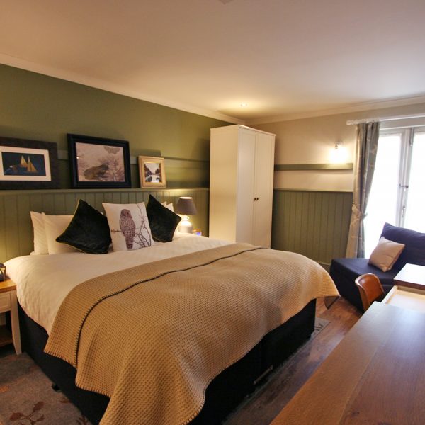Cosy Green Walled Boutique Hotel room with White Wardrobe